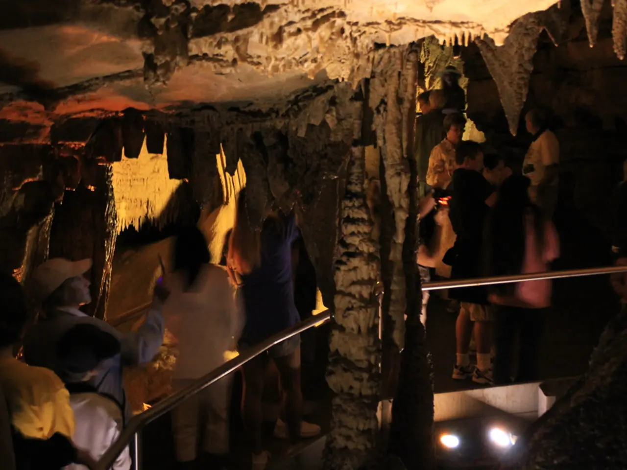 In this picture I can see few people standing and I can see lights and It looks like a cave.